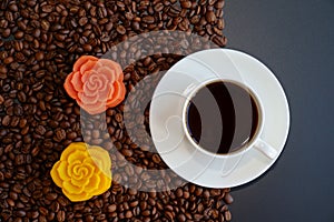 A cup of black coffee and colorful Chinese mooncakes on the coffee beans with black background