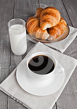 Cup of black coffee and croissant and milk