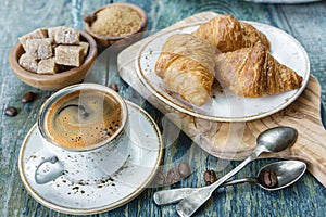 Cup of black coffee and croissants