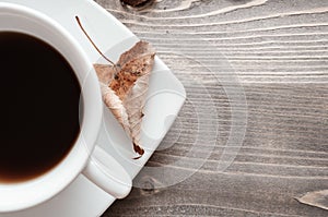 Cup of black coffee and dry leaf
