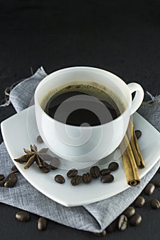 Cup of black coffee with foam on background of roasted coffee beans