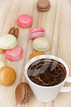 Cup of black coffee with french colorful macarons, sweet delight