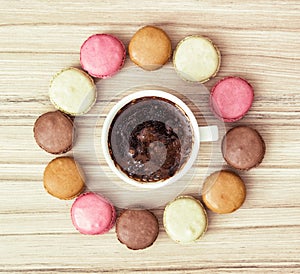 Cup of black coffee with french colorful macarons, view from above