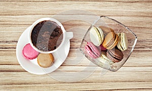 Cup of black coffee with french colorful macarons, view from above