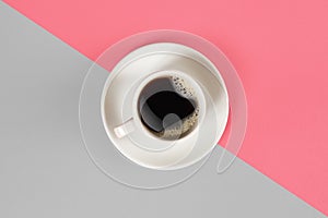 A cup of black coffee on gray and pink background. View from above.