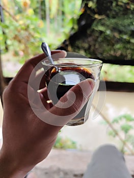 cup of black coffee in hand