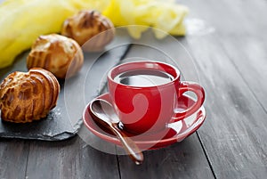 Cup of black coffee and little french eclairs