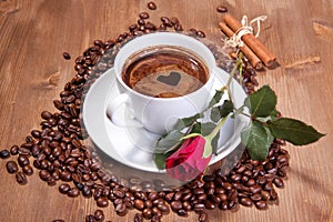 Cup of black coffee and red rose