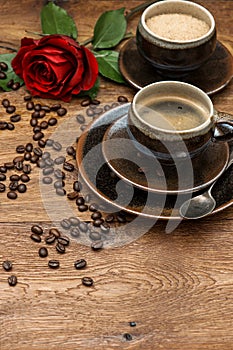 Cup of black coffee and red rose flower