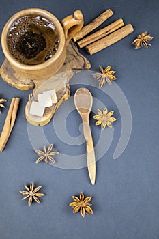 Cup of black coffee and spices on a blue background