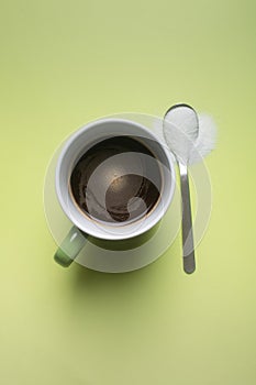 Cup of black coffee and spoon with sweetener