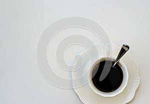 Cup of black hot espresso coffee with steam on white background. Top view, copy space. Morning espresso on table.