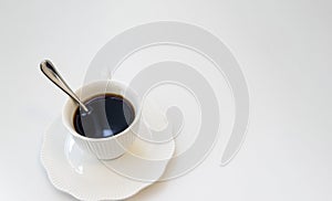 Cup of black hot espresso coffee with steam on white background. Top view, copy space. Morning espresso on table.