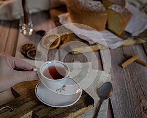 Cup of black tea with a freshly baled biscuit on a wooden table