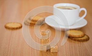 Cup of black tea with lemon, sugar and biscuits