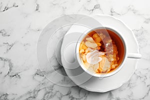 Cup with black tea and milk on marble tabl