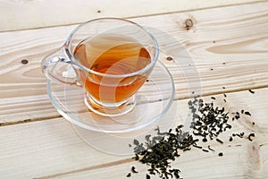 Cup of black tea with tea leaves