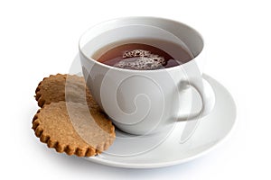 A cup of black tea with two gingerbread biscuits isolated on white. White ceramic cup and saucer.