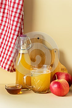 Cup and Bottle with Apple Cider with Cinnamon and Honey Yellow Background Seasonal Apple Mulled Wine Vertical