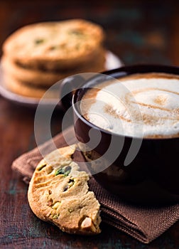 Cup of cafe au lait and pistachio cookie photo