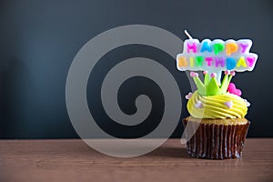 Cup cake and happy birthday text candle on cupcake ..Birthday cupcake with a happy brithday text candle.