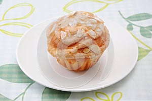 Cup cake muffin with almond and suggar on a plate on table cloth