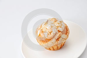 Cup cake muffin with almond and suggar on a plate on white background