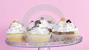 Cup cakes with white cream served on plate rotating