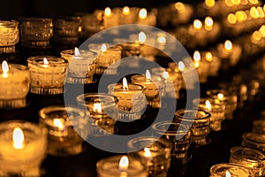 Cup of candle lighting on shelf in dark room