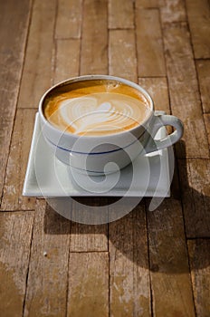 cup of cappucchino over wooden table