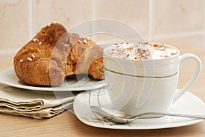 Cup of cappuccino and brioche