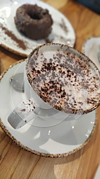 Cup of cappuccino with chocolate donuts