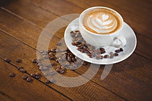 Cup of cappuccino with coffee art and coffee beans