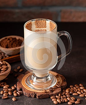 Cup of cappuccino with coffee beans on the table