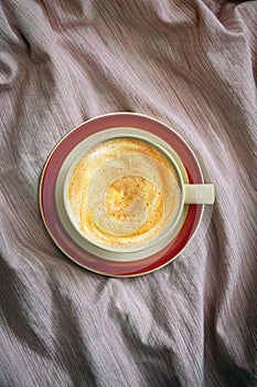 Cup Of Cappuccino Coffee In Bed On Crumpled Sheets