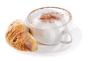 Cup of cappuccino coffee and croissant on white background