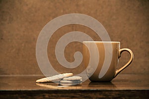 Cup of cappuccino coffee on dark table with cookies, colorful brown and clean