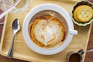 Cup of cappuccino coffee with heart shape latte art on old wood table Background, Latte coffee on old wooden Background table