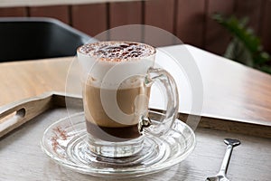 Cup of cappuccino coffee, hot mocha drink with cinnamon and coco