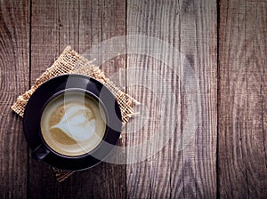 Cup of cappuccino coffee on old vintage wooden table