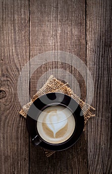 Cup of cappuccino coffee on old vintage wooden table