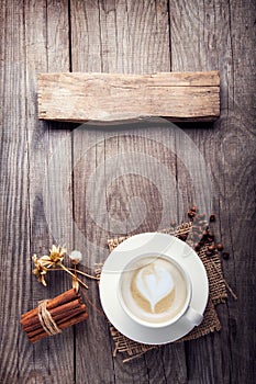 Cup of cappuccino coffee on old wooden table