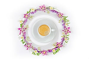 Cup of cappuccino coffee in a round vintage floral frame of Jasmine flowers and wildflowers on a white background top view close-u