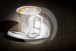 Cup of cappuccino coffee on vintage wooden table