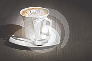 Cup of cappuccino coffee on vintage wooden table