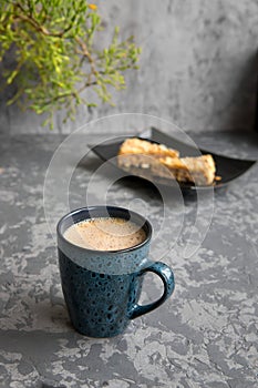 The cup of cappuccino on gray concrete table with almond cake. Breakfast concept. Selective focus, stories format