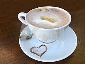 Cup cappuccino with heart of cocoa and decorated milk foam