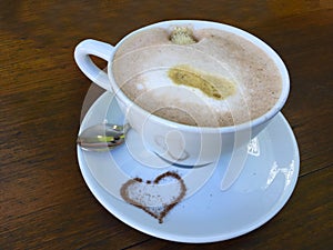 Cup cappuccino with heart of cocoa and decorated milk foam