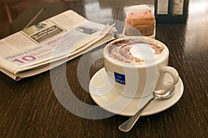 Cup of cappuccino and newspaper