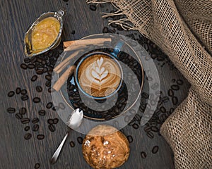 Cup of cappuccino with rosetta on brown table